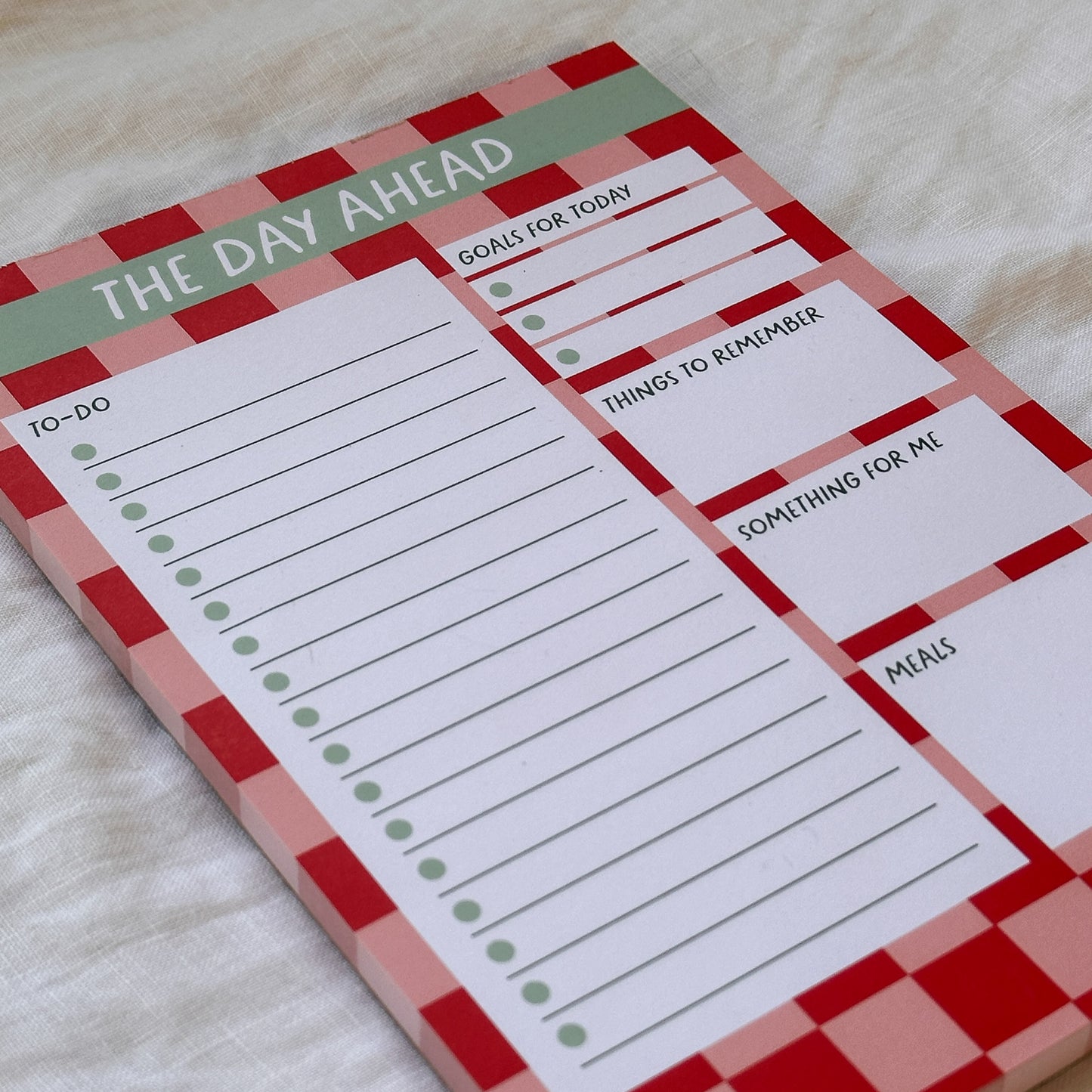 Notepad with daily planner sections on a light background