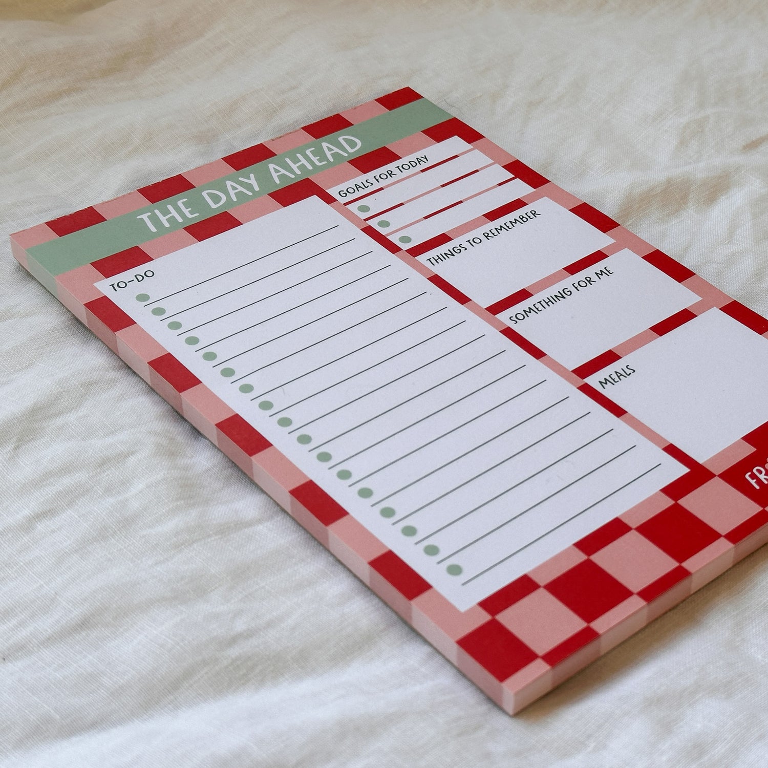 Notepad with checkered design and text on a light background