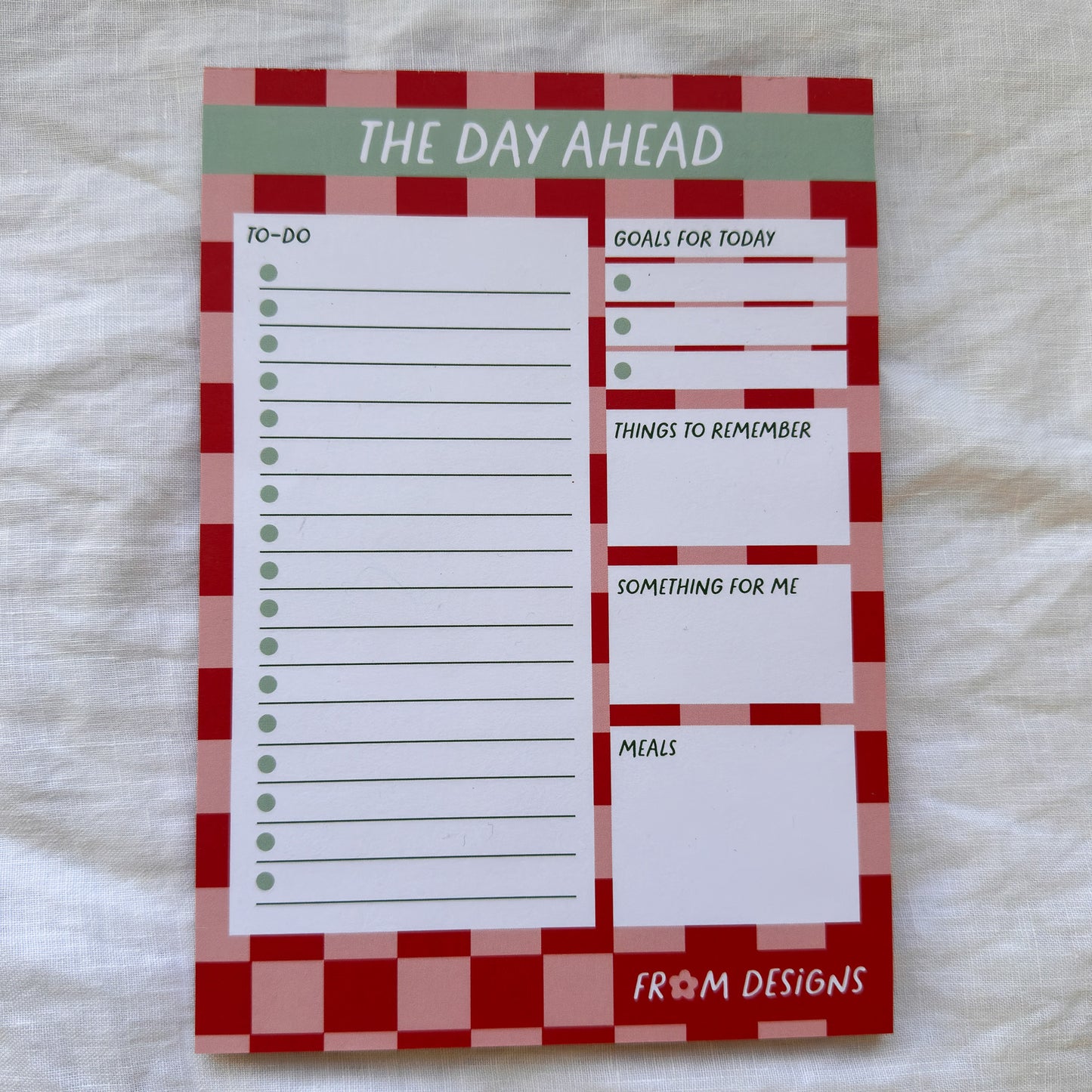Notepad with a checkered border and text sections on a white background